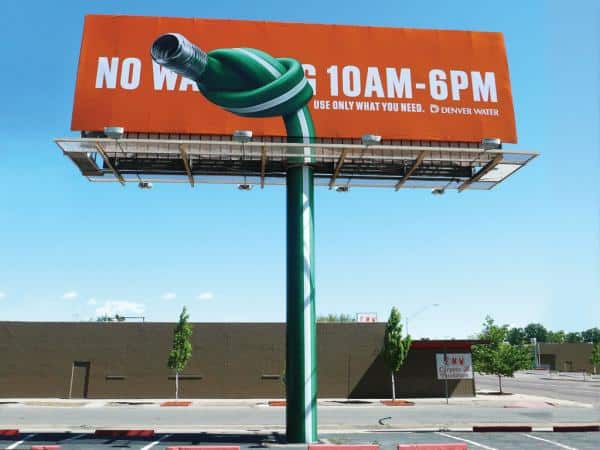 Denver Water billboard with knotted hose and watering restriction message