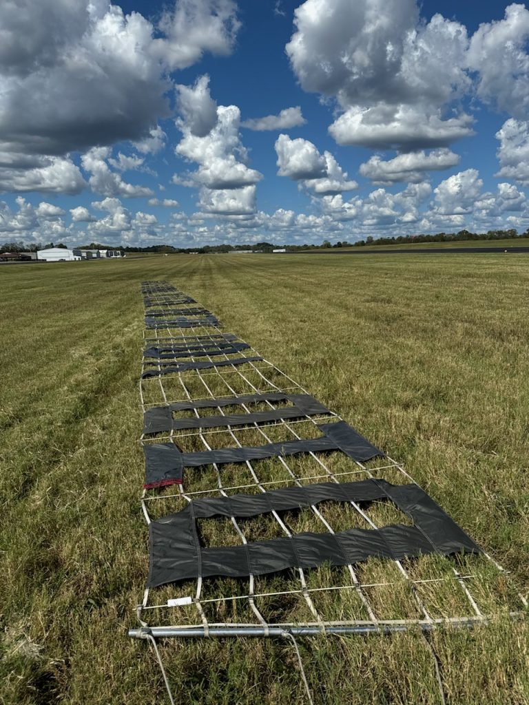 Aerial advertising banner laid out on airfield runway before airplane pickup