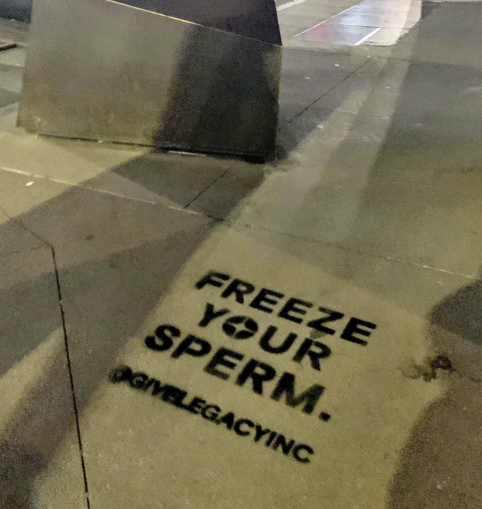 Chalk stencil advertisement reading "Freeze Your Sperm" on a New York City sidewalk for Legacy Inc