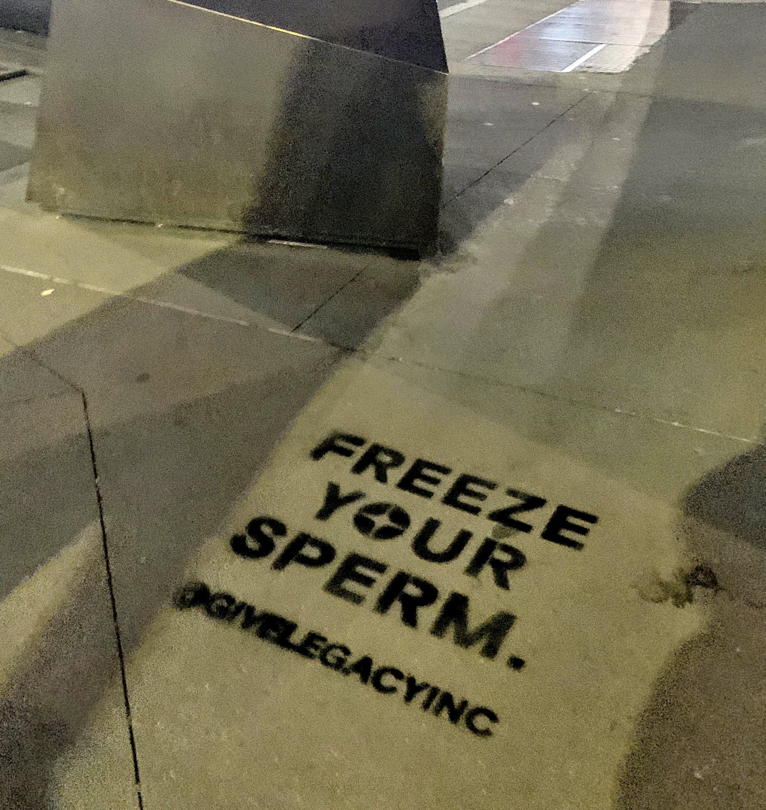 Chalk stencil advertisement reading "Freeze Your Sperm" on a New York City sidewalk for Legacy Inc