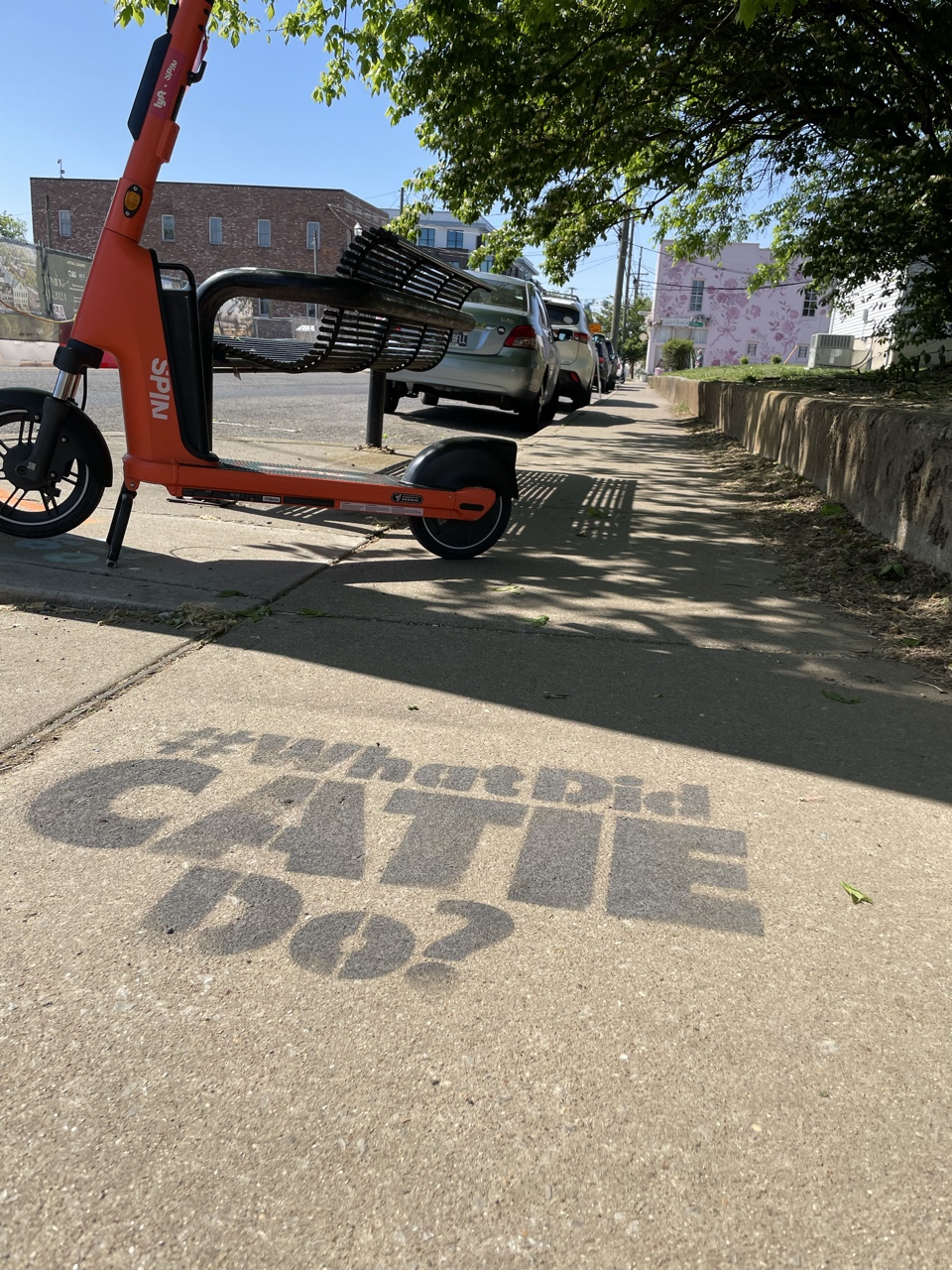 Chalk stencil reading "#WhatDidCATIEDo?" on a Nashville sidewalk near 12th Avenue and Ashwood Avenue