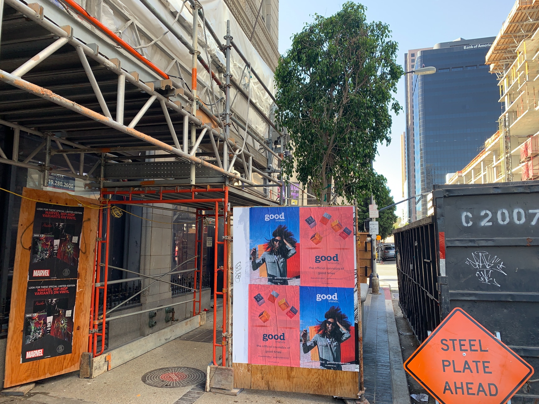 Wheatpasting posters on a construction corridor in downtown Los Angeles