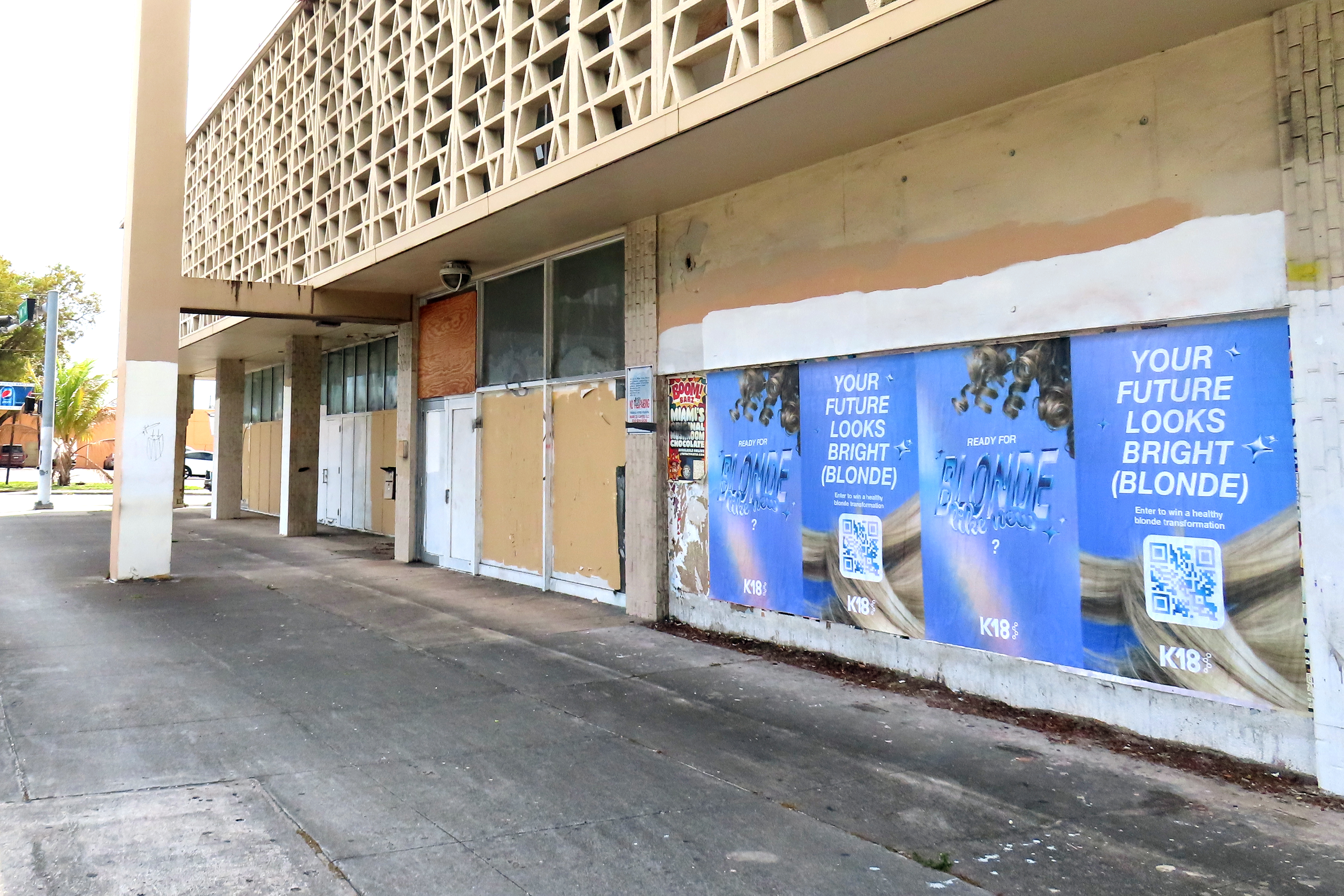 K18 hair wheatpasting campaign on a building wall in Miami