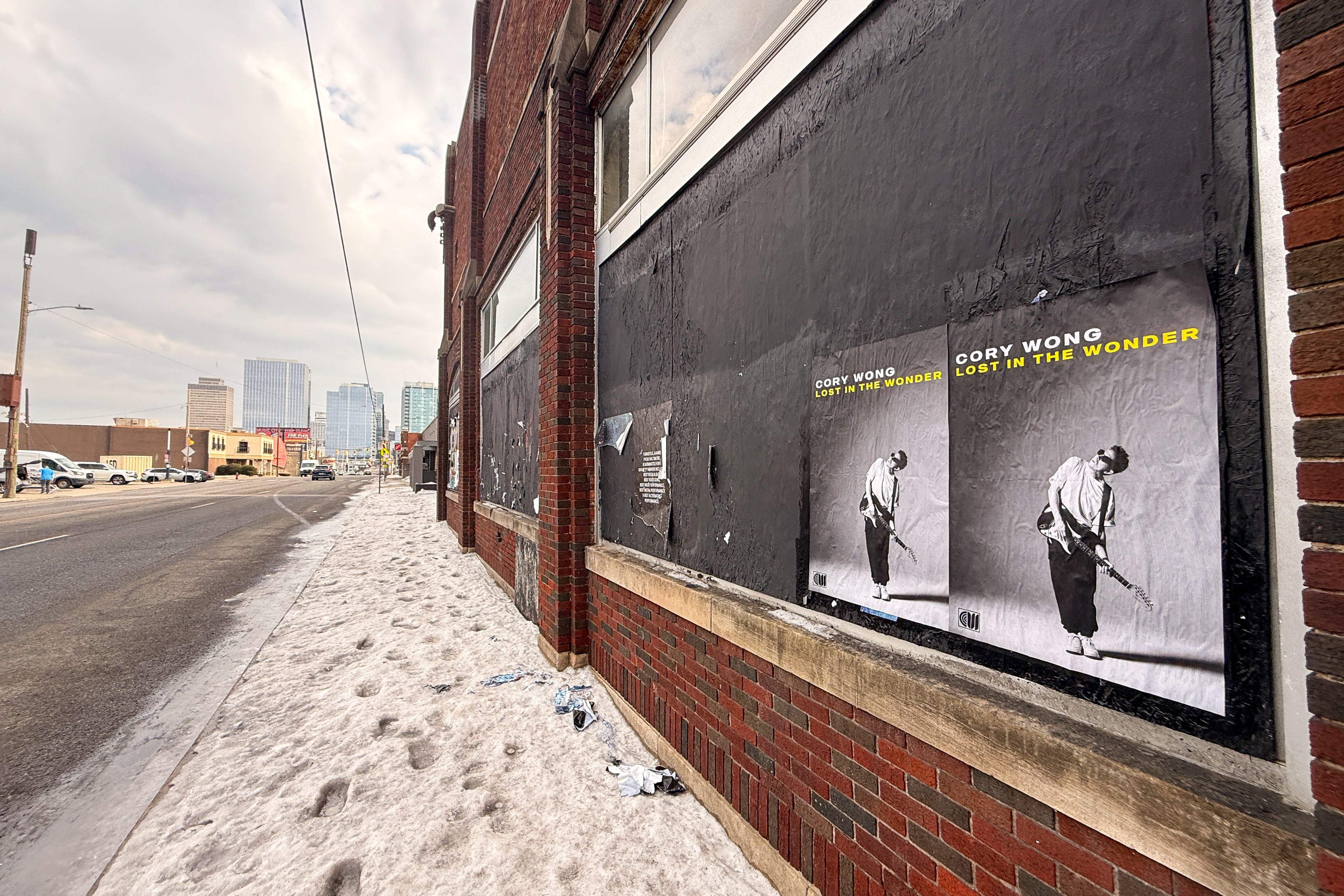 Cory Wong album wheatpasting posters on a brick building wall in Nashville