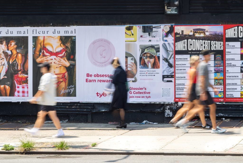 Wheatpasting posters on a New York City street barricade