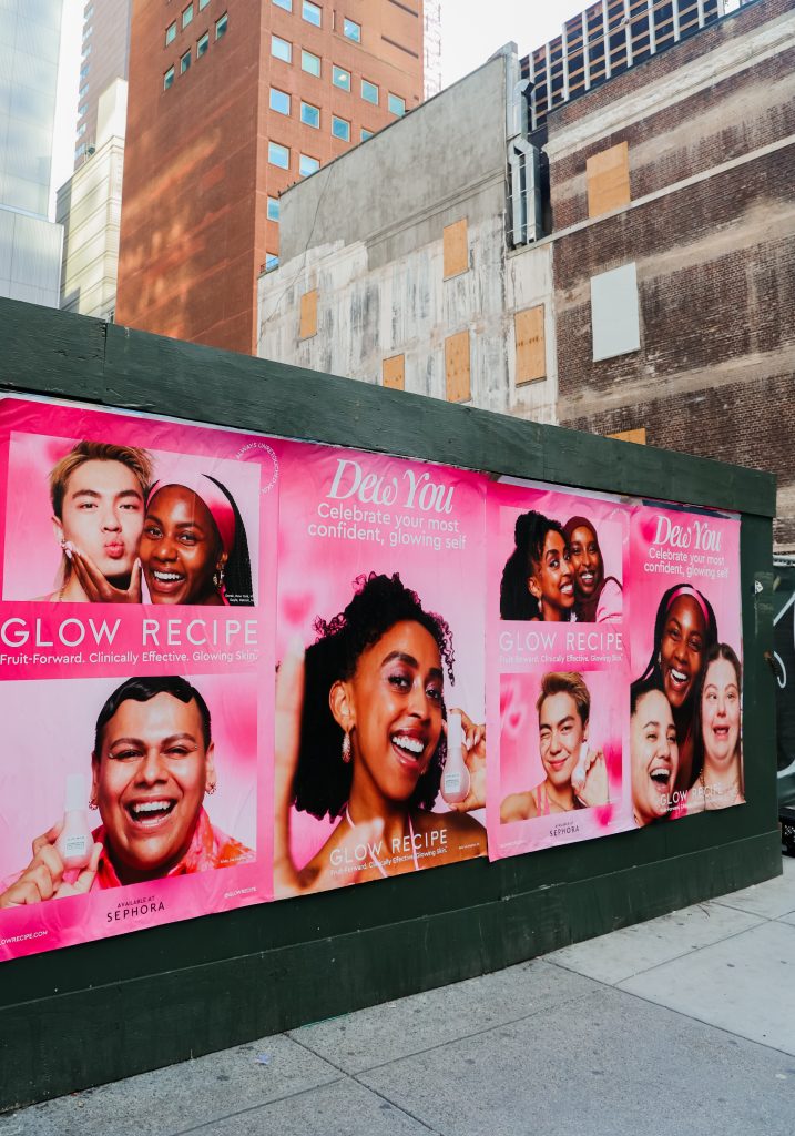 Glow Recipe wheatpasting campaign on a construction barricade in New York City