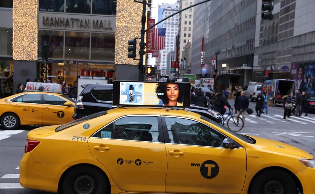 Maybelline digital rooftop display ad on a yellow NYC taxi cab in Manhattan