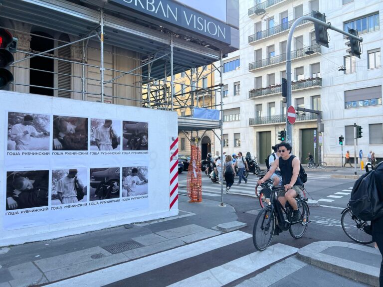 Gosha Rubchinskiy Wheat Pasting and Wild Posting® eight-panel corner takeover in Milan, installed on a hoarding adjacent to active scaffolding.