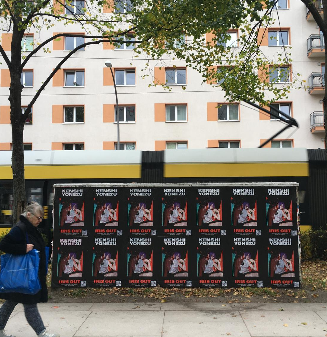 Kenshi Yonezu IRIS OUT wheat pasting takeover in Berlin Friedrichshain — 14-poster barricade for the Chainsaw Man: Reze Arc theme song, installed along a tram corridor as part of a Wild Posting® campaign by DASH TWO