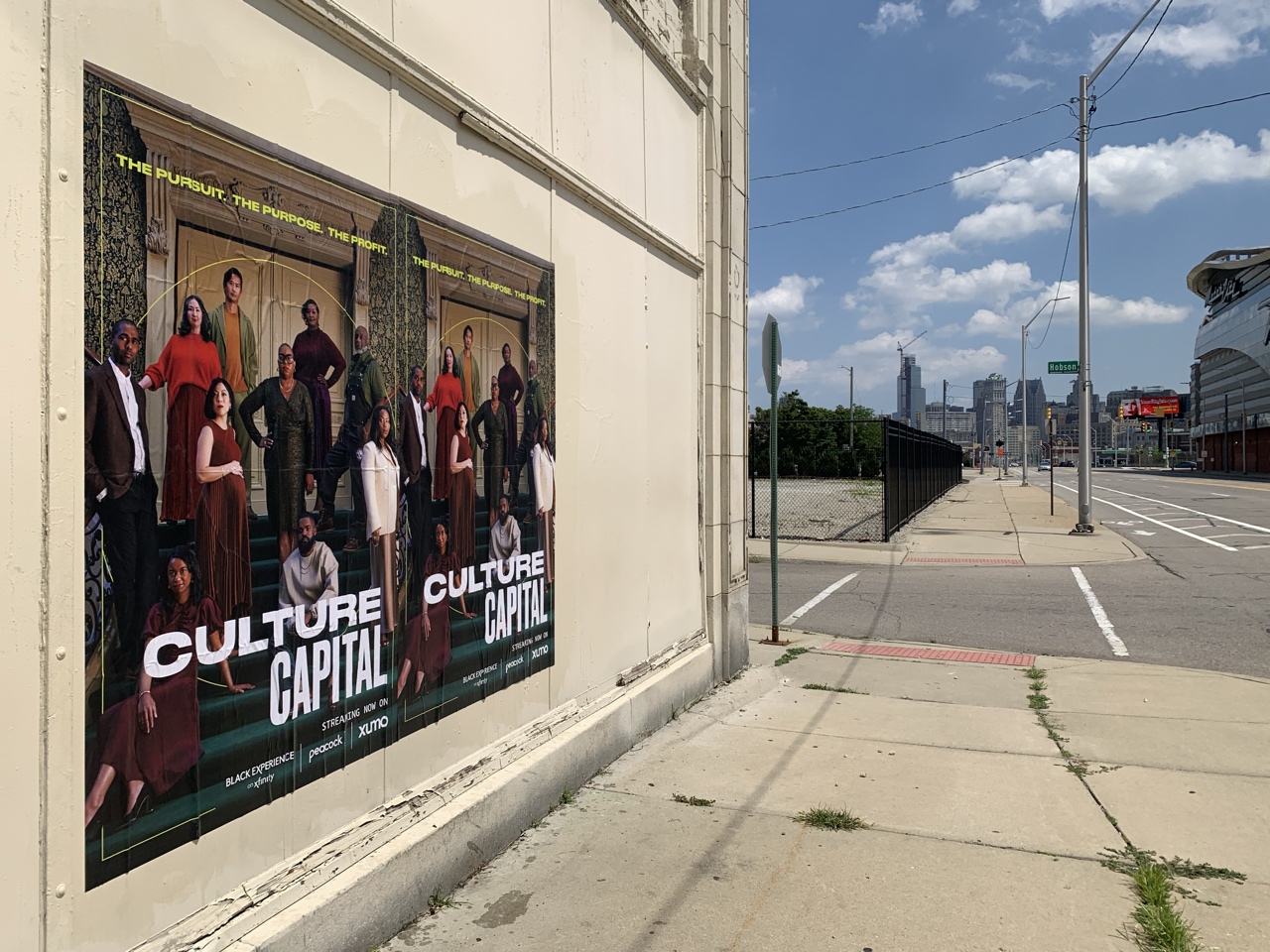Culture Capital Wild Posting® on Grand River Avenue in Detroit, near Little Caesars Arena and the Downtown skyline