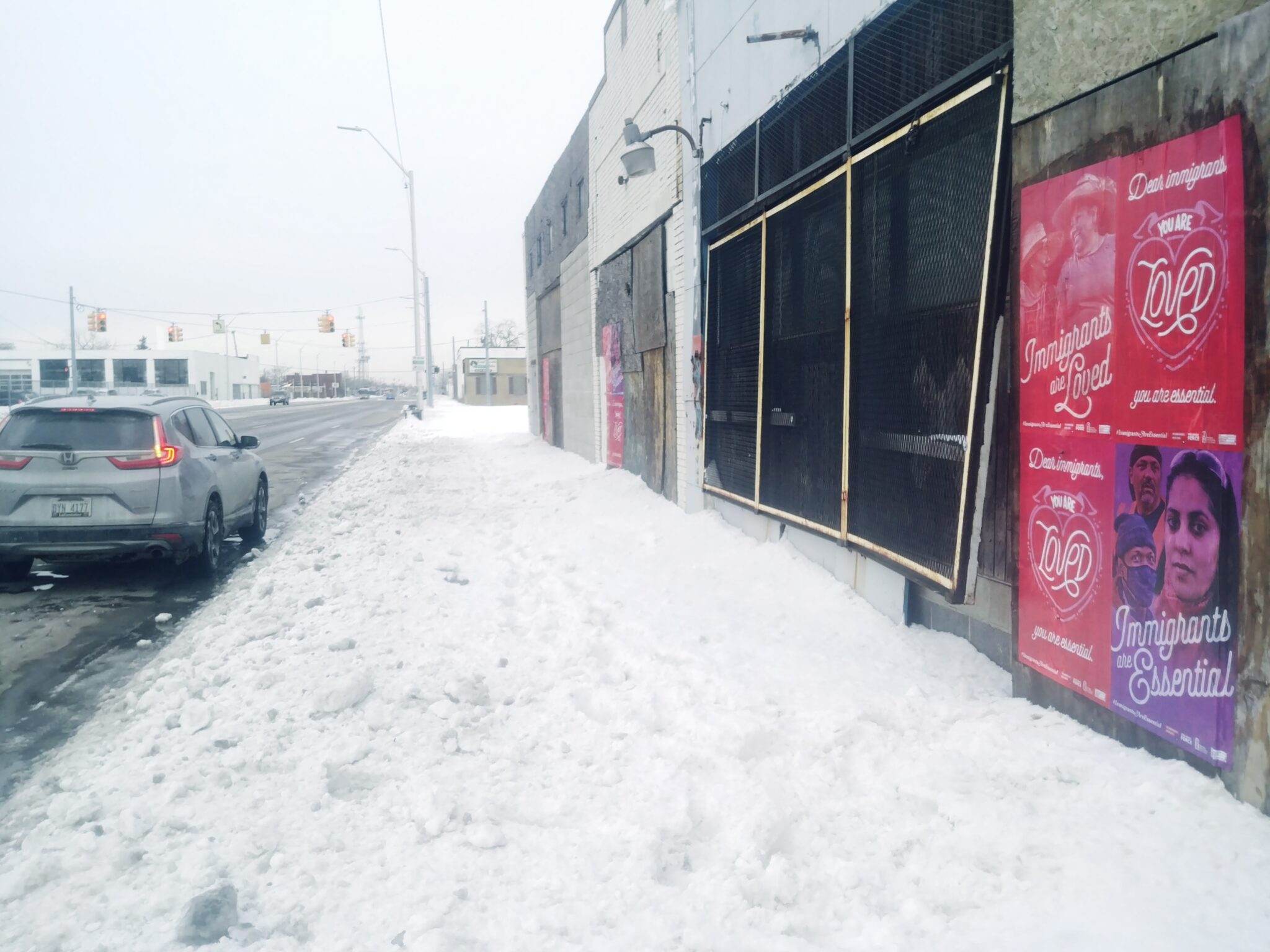 "Immigrants Are Essential" Wild Posting® campaign on Grand River Avenue, Detroit, during winter