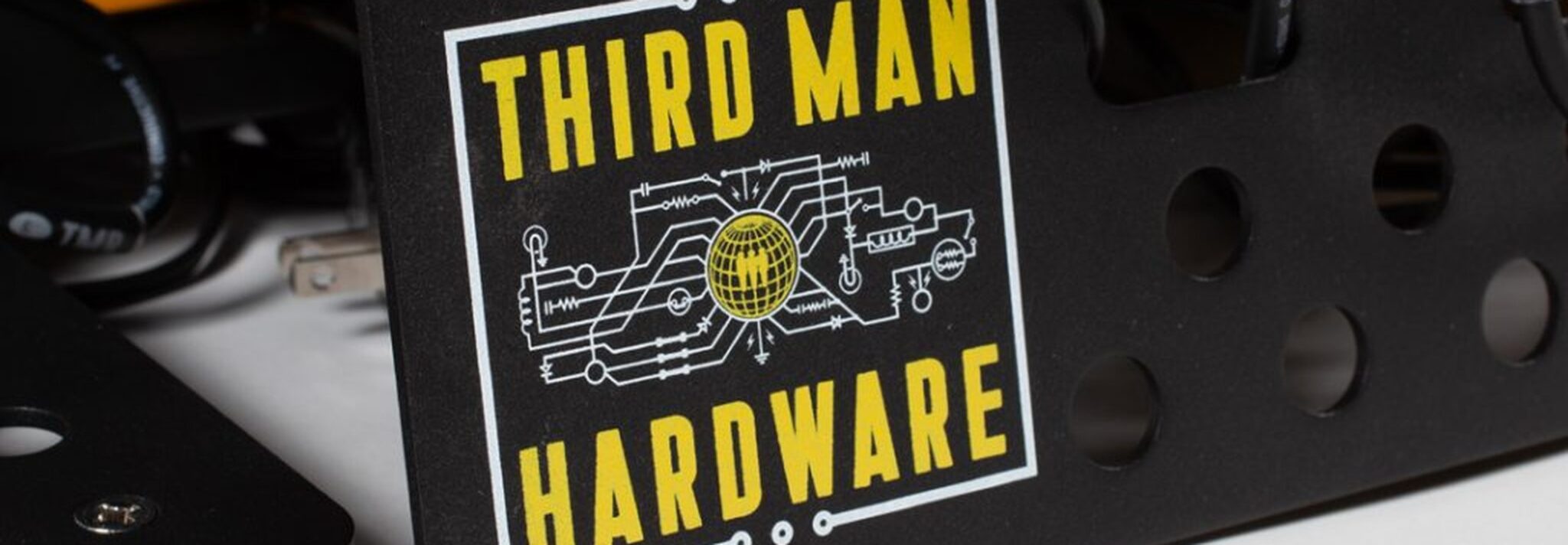 Sign reading 'THIRD MAN HARDWARE' with a yellow typography and circuitry graphic in the center of a black panel