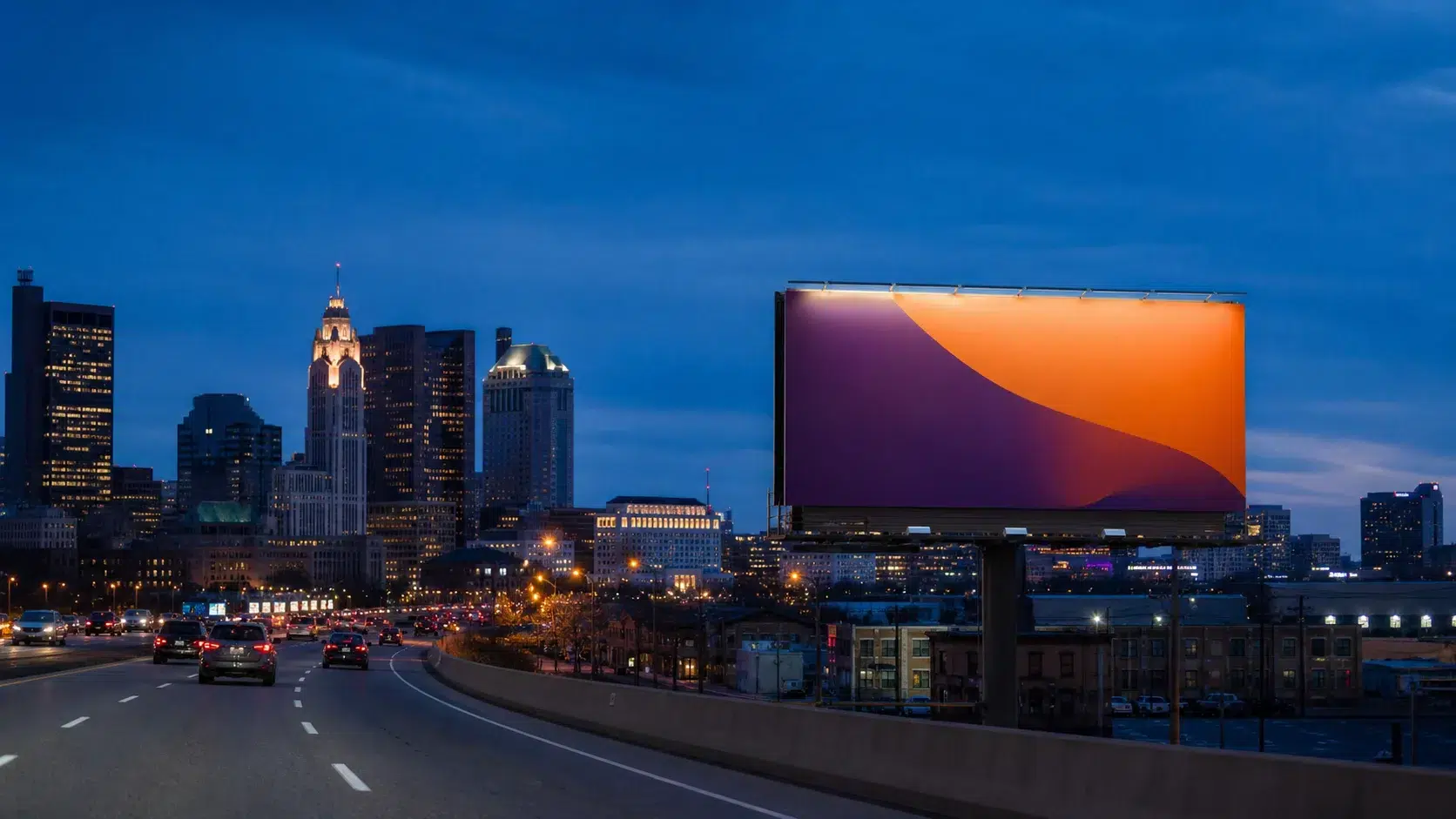 City skyline at dusk with a large colorful billboard on the freeway, displaying an orange and purple gradient.