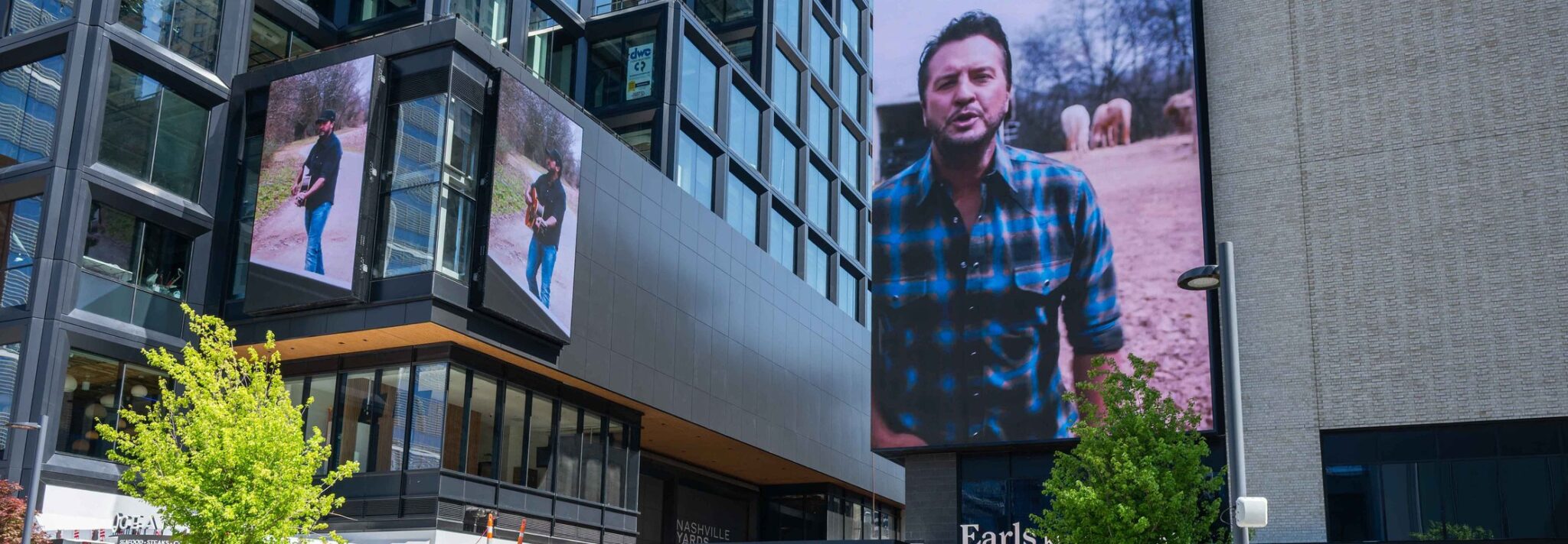 Luke Bryan's Signs album playing across multiple digital screens at Nashville Yards in downtown Nashville