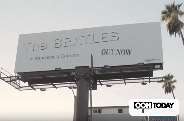 Billboard advertising The Beatles Anniversary Editions with 'OUT NOW' text; palm trees in the background and an 'OOH TODAY' watermark at the bottom right.