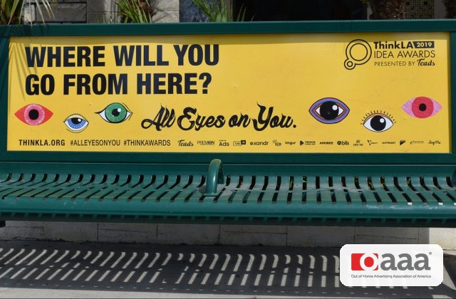 Yellow bench advertising banner: 'Where will you go from here? All Eyes on You.' with colorful eye illustrations (ThinkLA Idea Awards).