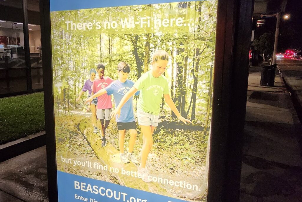 Backlit bus shelter glowing at night in Los Angeles running a Boy Scouts of America Discover Scouting campaign
